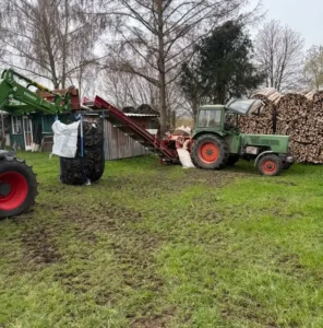 Befüllung mit Förderband und zwei Schleppern auf der Wiese