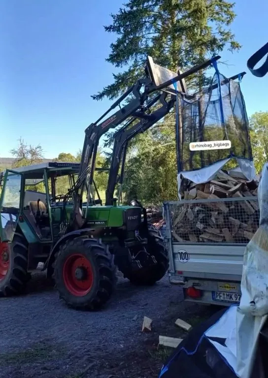 Schlepper mit Frontlader setzt einen gefüllten Bag auf den Anhänger