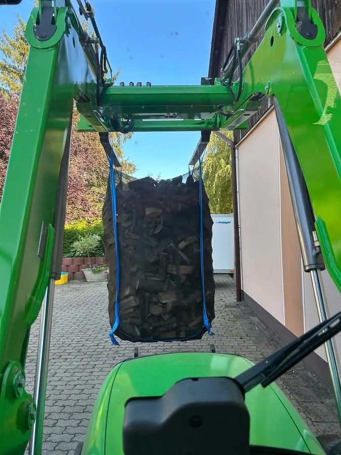 Gefüllter Bag hängt am Frontlader, Blick aus der Kabine